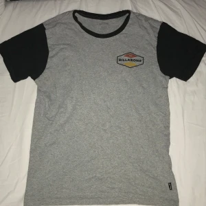 Grå och svart t-shirt från Billabong - Säljer en snygg grå t-shirt från Billabong med svarta ärmar. 