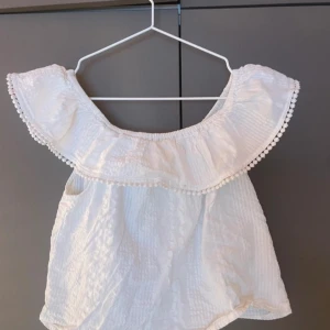 Vit offshoulder topp med volang - Så fin vit topp som tyvärr är för liten. Man kan även använda den som one shoulder och off shoulder! Storlek S men sitter som xs💕