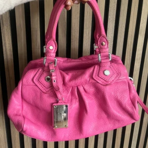 Marc Jacobs väska - Marc Jacobs classic q baby groove med silvriga detaljer. Väskan är rosa. Axelremband ingår. Den är ca 30 cm bred och är i den lilla modellen. Perfekt skick. Fler bilder finns och svarar gärna på frågor 🩷