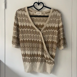 Beige och brun omlottkofta från Massimo Dutti - Säljer en snygg beige och brun omlottkofta från Massimo Dutti med missoni liknande mönster. Köpt här på plick men aldrig använd. Den är insydd i midjan men det går lätt att sprätta upp!🤍🤍🤍 pris kan diskuteras