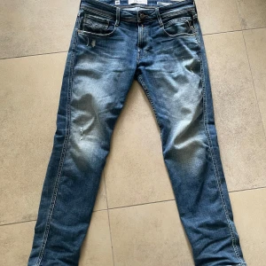 Ljusblåa replay anbass jenas - Sköna jeans med lite slitningar. Replay anbass så slim fit, storlek w32x32. 