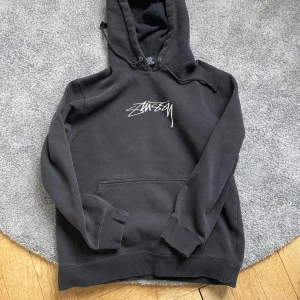 Svart hoodie från Stüssy - Säljer en svart hoodie från Stüssy med  logga tryckt på bröstet. Inga skador, bra skick. Pris kan diskuteras. Frågor? Skriv bara :) 