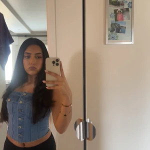 Jeans korsettopp med knappar - Snygg jeans korsettopp med knappar framtill och fickdetaljer. Perfekt för en trendig look. Köpt från H&m för 250kr 