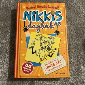 Nikkis dagbok #3 - Nikkis dagbok #3 av Rachel Renée Russell är en färgglad bok med orange omslag och illustrationer. Boken handlar om berättelser från en (inte så) talangfull popstjärna. Perfekt för ungdomar som gillar humor och dagboksformat.
