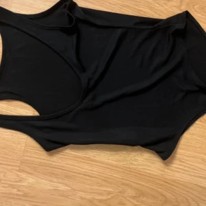Svart body  - Snygg svart ärmlös linnetopp i ett mjukt och stretchigt material. Perfekt för lager-på-lager eller att bära som den är. Enkel och stilren design som passar till det mesta.