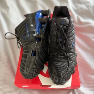 Nike Shox TL - Säljer ett par svarta och blå Nike Shox TL med lådan Skorna har en sportig design med meshdetaljer för extra andningsförmåga. Perfekta för träning eller en aktiv livsstil.