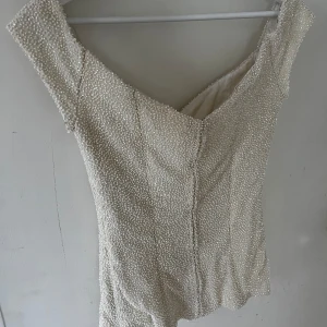 Korsett med pärlor - Benvit off shoulder korsett med insydda pärlor. Den passar en storlek S