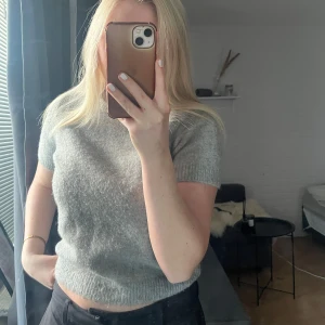 Grå stickad t shirt - Säljer en mjuk grå stickad t shirt från Zara. Perfekt som basplagg i garderoben. Säljs då den inte används längre.                                                                               🩶🩶🩶
