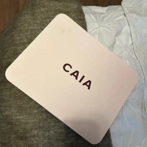 Caia julkalender med alla satin påsar - Elegant sminkspegel från CAIA i en stilren box med vinröd insida. Perfekt för att ha med sig på resan eller för att organisera smink hemma. Boxen har en praktisk spegel på insidan av locket.