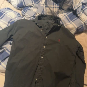 Svart långärmad skjorta från Ralph Lauren - Snygg svart skjorta från Ralph Lauren ny pris 1600kr. Den är lite trasig därför priset.