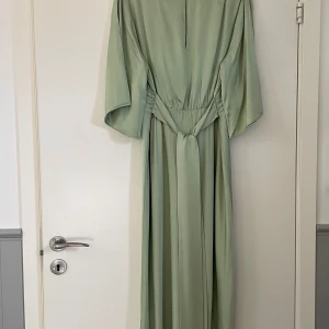 Grön långklänning  - Elegant grön långklänning, v-ringning o vida ärmar. Aldrig använd, nypris 999. Pris går att diskuteras vid snabb affär💞