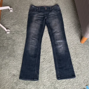 Lågmidjade jeans - Mörkblå utsvängda lågmidjade jeans. Midjemått:39,5 cm   Innerbenslängd:82 cm