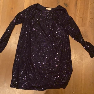 Lila/blå glittrig klänning från A View - Snygg lila blå klänning från A View, täckt med glittriga paljetter som ger en festlig look. Klänningen har långa ärmar och en elegant passform som passar perfekt för en utekväll. Perfekt för dig som vill sticka ut och glänsa! Ord pris 1200kr aldrig använd 