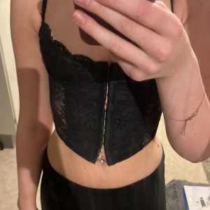 Topp - Säljer denna fina korsett liknande toppen. Formar sig efter kroppen och sitter super fint 