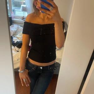 Svart offshoulder topp - Snygg svart offshoulder topp som är perfekt för en stilren look. Toppen har en tight passform och är tillverkad i ett mjukt material som sitter bekvämt. Perfekt för att klä upp eller ner beroende på tillfälle.