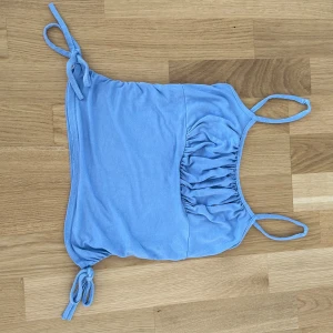 Ljusblått linne - Ett jätte gulligt ljusblått linne med snören på sidan ( går ej att justera tröjan med snörena, dem är endast till för att den ska se fin ut) 💕. 