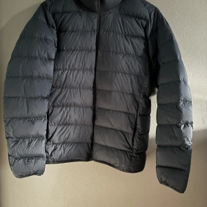 Svart dunjacka från Uniqlo - Säljer en blå (navy) dunjacka från Uniqlo i storlek S. Den är superlätt och perfekt för kyliga dagar. Jackan har en stilren design med långa ärmar och är quiltad för extra värme. Perfekt för både höst och vinter! Nypris: 899kr