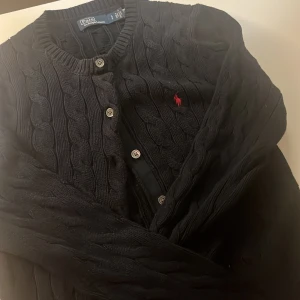 Polo Ralph lauren kofta - Stickad kofta med flätnönster från polo Ralph lauren. Köpte den för unge för 1400kr men säljer för 900kr.