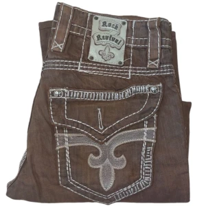 Rock Revival jeans - Rock Revival jeans. W31. Saknar knapp på högra fickan. Uppsydda och insydda längst ner. [Ytterbenslängd 100cm] [Innerbenslängd 71cm] [Midja 43cm] [Benöppning 20cm]