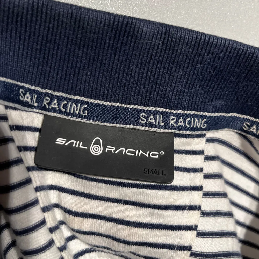 Säljer en blå och vit randig piké från Sail racing i storlek s, använt skick.. T-shirts.