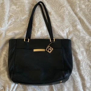 Calvin Klein väska  - Vet ej om den e äkta Elr inte men tror de  man får plats med mkt grejer och de är två små fack och ett med dragkedja och ett fack på utsidan pris kan diskuteras 