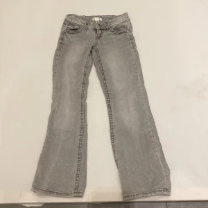Grå jeans från Gina Tricot - Snygga grå jeans från Gina Tricot i storlek 146. De har en klassisk femficksdesign och en bootcut-stil som ger en avslappnad look. Perfekta för en trendig vardagsstil.