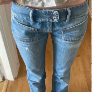 Diseljeans - Snygga blå jeans med dubbla knappar och en cool tvättad look. De har framträdande fickor och en bekväm passform. Perfekta för en avslappnad stil. Väldigt fint skick och mycket eftertraktade i storlek 24 