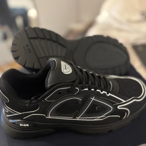 Dior - Snygga svarta sneakers från Dior med vita detaljer och märkets logga på sidan. Skorna har en modern design med snörning och en bekväm sula. Perfekta för en stilren look. Pris kan såklart diskuteras och kvitto kommer med😀, andra färger finns också 