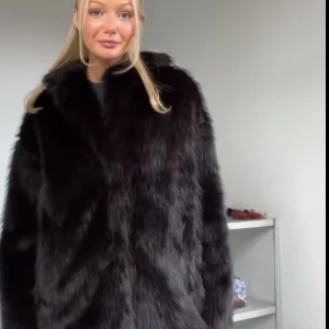 Svart pälsjacka - Snygg och elegant svart pälsjacka med långärmad design. Perfekt för att hålla sig varm och stilren under kallare säsonger. Jackan har en klassisk look och passar till många olika outfits. Aldrig använd (prislapp på) köpt för 600kr Storleken är Xs/S men passar även M