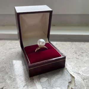 Elegant ring med pärla - Säljer en elegant ring med en stor vit pärla. Ringen har en stilren design och kommer tyvärr inte i asken. Perfekt för speciella tillfällen eller som en fin present.