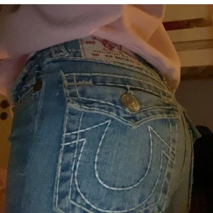 Blå jeans från True Religion - Säljer ett par snygga blå jeans från True Religion.  De är lågmidjad och bootcut. Säljer pga de är tyvärr för små för mig. Lånade bilder från tidigare ägare jag köpte ifrån. Väldigt bra skick💗 