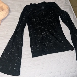 Svart spets tröja - Säljer en svart tröja med spets mönster. Tröjan har långa ärmar och en elegant passform som passar perfekt för festliga tillfällen. Materialet är mjukt och bekvämt.