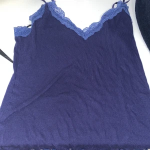 Mörkblå ribbad linnetopp från Amisu - Snygg mörkblå ribbad linnetopp från Amisu med spetsdetaljer vid halsringningen. Perfekt för en stilren look. 💙