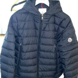 Moncler Galion  - Säljer en stilren blå tunn dunjacka från Moncler med huva och dragkedja. Förmodligen Monclers snyggaste jacka, riktigt fet och räkna med komplimanger och blickar:) . Slutsåld överallt.              Köpt för 14 lax på END och kvitto finns. Givetvis original till skillnad från mycket annat här. Dessvärre ett litet hål som jag sytt och inte syns. Bortsett från det är den i stort sett ny! Storlek 3 vilket motsvarar M/L beroende på hur du vill att den ska sitta. Passa på att göra ett sjukt bra fynd! 
