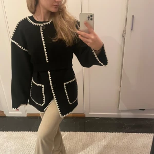Svart jacka med vita detaljer - Snygg svart kavaj med vita kantdetaljer och knappar framtill. Den har en normal passform och långa ärmar. Perfekt för en stilren look. Säljer den då jag hann inte returnera den i tid, därför är den helt ny och oanvänd. Pris kan diskuteras vid snabb affär! Storleken är XS men jag upplever att den funkar som S och M också! 