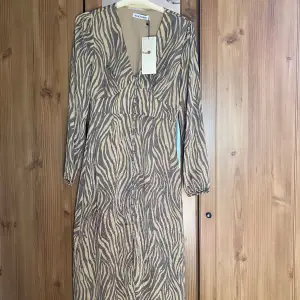 Adoore Paris dress midi helt oanvänd säljes. Färg brown zebra, stl 34. 