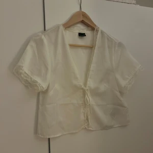 Gina Tricot Blus 🤍 - Jättefin blus från Gina Tricot med spetskant och knytning i mitten. Bara använd en gång 