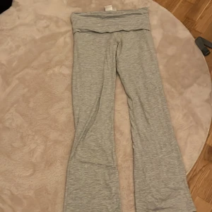 Grå mjukisbyxor från Gina Tricot - Säljer ett par superbekväma grå mjukisbyxor från Gina Tricot. De har en loose passform och är perfekta för en avslappnad dag hemma eller en chill dag ute. Byxorna är gjorda i mjukt material och har en bred linning för extra komfort. Perfekta för höst