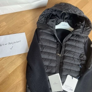 Moncler Padded Wool Hooded Cardigan - En Moncler Jacka/Cardigan för dig som vill komma så nära butiksskick som möjligt utan att behöva betala 12.000 kr. Allt från butik medkommer, prislapp, fysiskt kvitto, påse med mera. Köpt på birgerjarlsgatan och kan hämtas i Tyresö. 10/10 Skick.