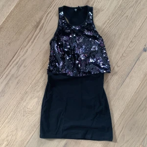 Svart paljettklänning från H&M - Säljer en superfin svart klänning från H&M Conscious Collection. Den har en glittrig paljettöverdel som verkligen fångar ljuset och ger en festlig känsla. Klänningen är ärmlös och har en tight passform som framhäver figuren. Perfekt för en utekväll eller fest! 🖤✨
