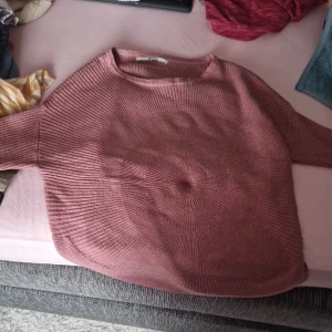 Rosa stickad tröja från ONLY - Säljer en supermysig rosa stickad tröja från ONLY. Den har en avslappnad passform och är perfekt för kyliga dagar. Tröjan är ribbad och har långa ärmar, vilket gör den både stilren och bekväm. Perfekt för höst och vinter! 💖