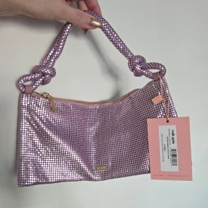 Cult Gaia's Hera nano shoulder bag - Cult Gaia's Hera Nano Shoulder bag i lilac färgskimrande metallskal. Mått: H14cm, B28cm, D8cm. Aldrig använd, kommer med dustbag.