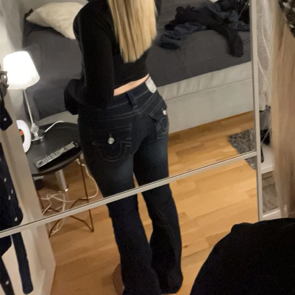 Populära utsvängda jeans från True Religion med låg midja. Stretchigt material med låg midja. Figurnära passform upptill med utsvängda ben, bakfickor med ficklock och knapp. Dragkedjegylf med knapp. Älskar dessa men lite långa på mig. Nypris 1299kr.. Jeans & Byxor.