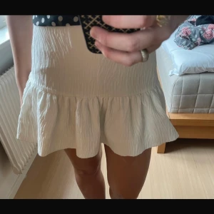 Zebra glittrig kjol  - Glittrig vit zara kjol med coolt zebra mönster. Kjolen har inbyggda shorts med det är inget som syns, kjolen har även en dragkedja vid ena sidan. Nyskick! Storlek m men passar även s!💕