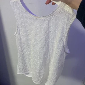Vit spetslinne från Stradivarius - Säljer ett superfint vitt spetslinne från Stradivarius. Det är ärmlöst och perfekt för sommardagar eller som ett lager under en kavaj. Linnet har ett vackert spetsmönster som ger en romantisk touch. Perfekt för både vardag och fest! 🌸