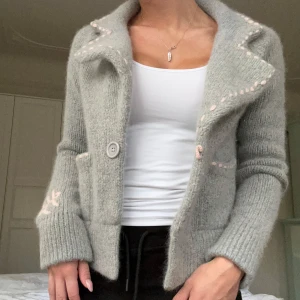 Grå stickad kofta - Henri Lloyd - Superfin grå stickad kofta ifrån Henri Lloyd med rosa söta detaljer💕 Storlek 2 men skulle säga att det är en S💕 I mycket fint skick och perfekt nu till hösten💕 