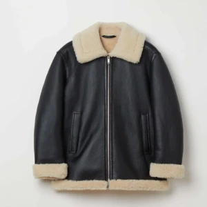Svart skinnjacka med foder från ss - The Leather Shearling Jacket – a true classic reimagined to keep you warm when the cold wind is blowing. Crafted with meticulous attention to detail, this archetypal piece has a relaxed fit without becoming oversized.org pris - 10.000