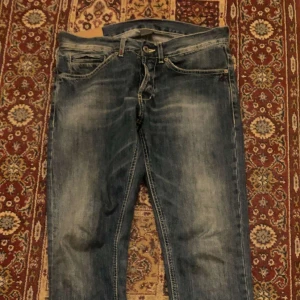 Dondup George W33 - Ett par snygga, stilrena DonDup George i storlek W33. Jeansen är slim fit och passar mig som är 185cm 75kg, men de sitter aningen tight och skulle förmodligen passa någon som antingen är kortare eller lättare bättre. Inga tydligt synliga defekter på jeansen, och de är i riktigt schysst skick. 8/10 🙏. Kontakta mig om du vill ha fler bilder eller om du har fler frågor om dem.