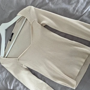 Beige ribbad topp från Gina Tricot - Säljer en stilren beige ribbad topp från Gina Tricot. Toppen har en v-ringad design och långa ärmar, perfekt för en chic och avslappnad look. Passar utmärkt till både jeans och kjol. Hör av dig vid intresse! 🤍