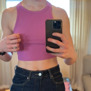 Rosa ribbad linnetopp från Zara - Säljer en snygg rosa ribbad linnetopp från Zara. Toppen är ärmlös och croppad. Kommer inte till använding! Säljer även i blått och gult!